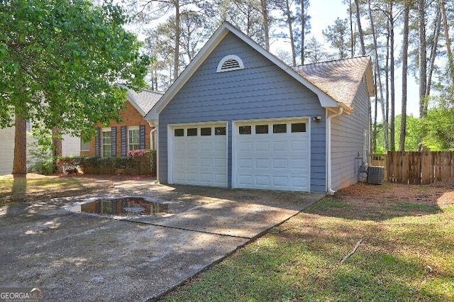 garage with central AC, fence, and concrete driveway
