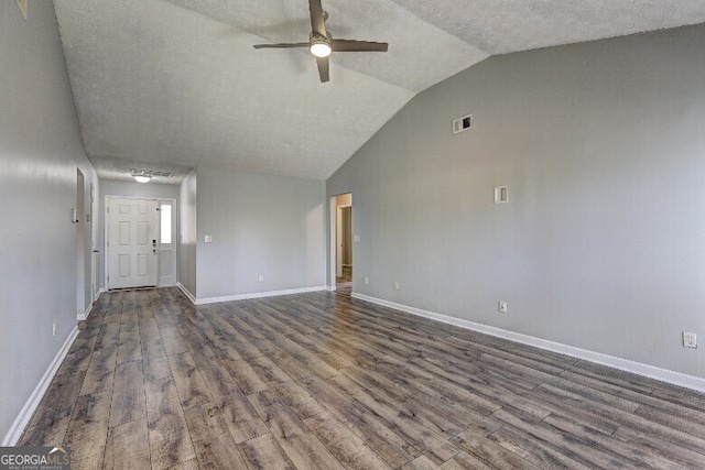 unfurnished living room featuring baseboards, vaulted ceiling, a textured ceiling, dark wood-type flooring, and ceiling fan