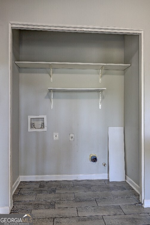 clothes washing area featuring baseboards, hookup for a gas dryer, laundry area, hookup for a washing machine, and wood finished floors