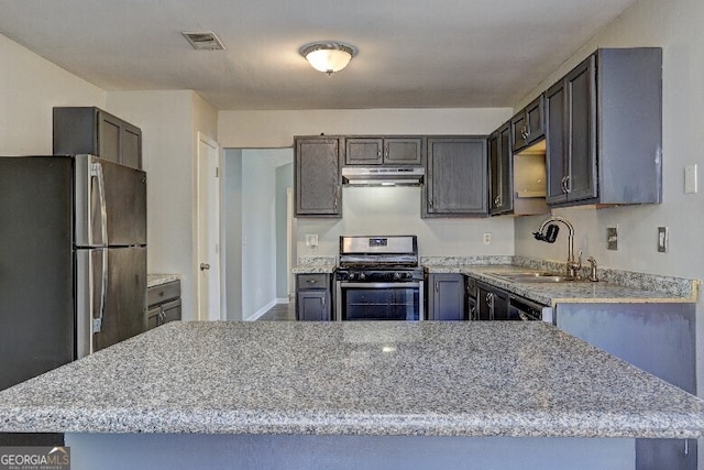 kitchen with light stone counters, under cabinet range hood, visible vents, stainless steel appliances, and a sink