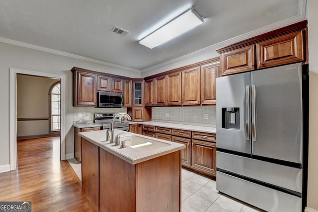 kitchen featuring stainless steel appliances, visible vents, light countertops, and backsplash