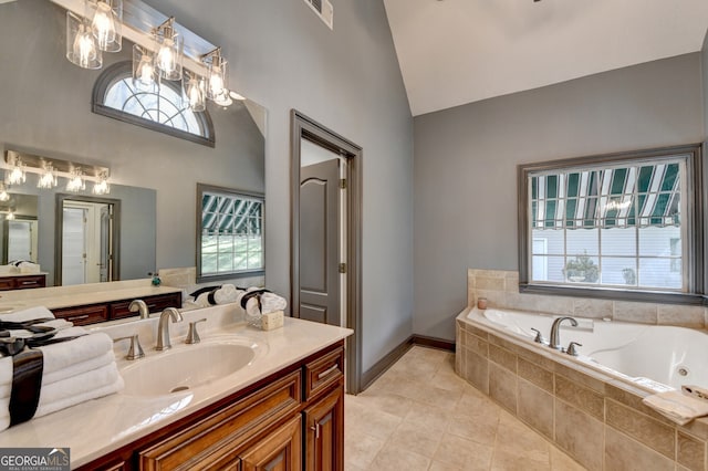 full bath with a whirlpool tub, vanity, tile patterned flooring, visible vents, and lofted ceiling