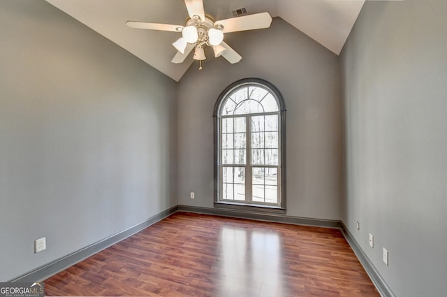 unfurnished room featuring lofted ceiling, baseboards, visible vents, ceiling fan, and wood finished floors