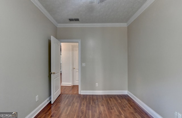 unfurnished room featuring baseboards, ornamental molding, a textured ceiling, visible vents, and dark wood finished floors