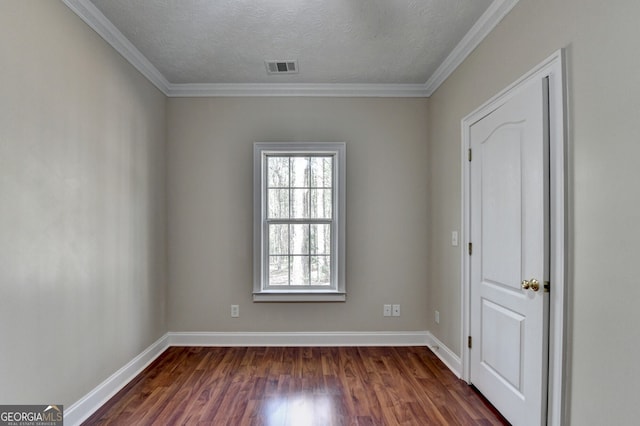 empty room with a textured ceiling, baseboards, dark wood finished floors, and visible vents