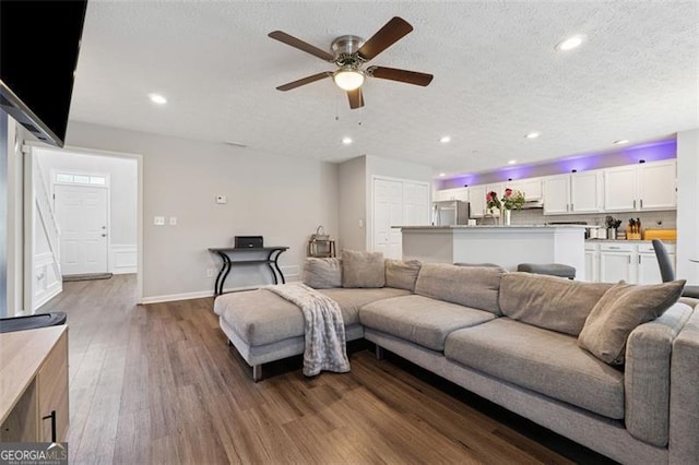 living area featuring baseboards, recessed lighting, a textured ceiling, ceiling fan, and wood finished floors