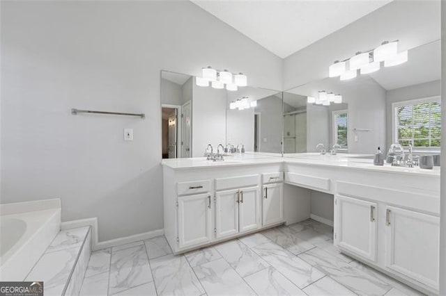 full bathroom featuring vanity, vaulted ceiling, a stall shower, marble finish floor, and a garden tub