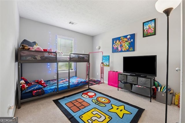 bedroom with carpet floors, visible vents, and a textured ceiling