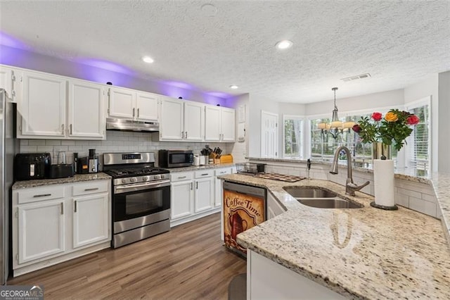 kitchen with a sink, dark wood finished floors, under cabinet range hood, white cabinetry, and stainless steel appliances