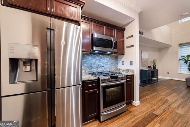 2626 Peachtree Rd NW Unit 412, Atlanta, GA 30305 - kitchen featuring light stone countertops, light wood-style flooring, visible vents, appliances with stainless steel finishes, and decorative backsplash