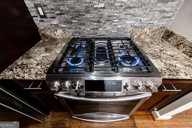 2626 Peachtree Rd NW Unit 412, Atlanta, GA 30305 - room details with stone countertops, wood finished floors, backsplash, and stainless steel gas range oven