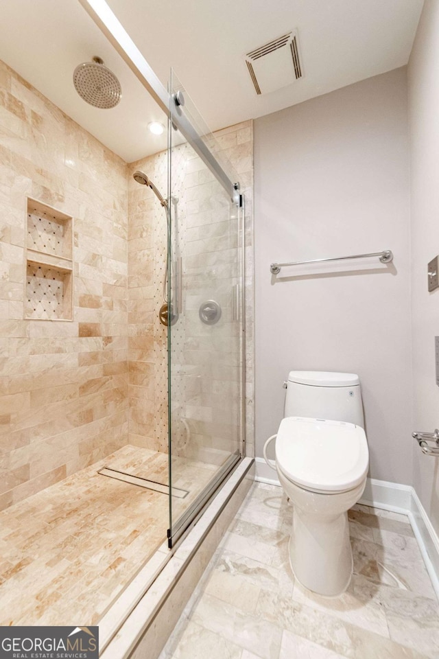 2626 Peachtree Rd NW Unit 412, Atlanta, GA 30305 - full bath with baseboards, toilet, a shower stall, visible vents, and marble finish floor