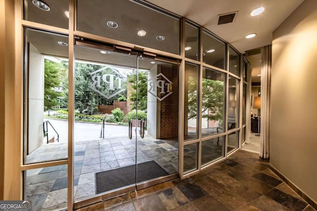 2626 Peachtree Rd NW Unit 412, Atlanta, GA 30305 - doorway to outside with stone tile floors, baseboards, visible vents, and expansive windows