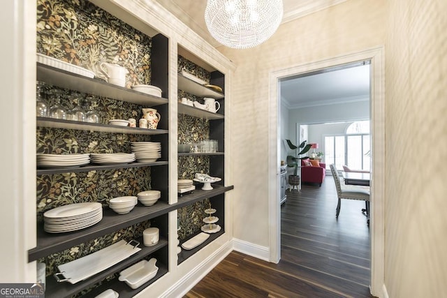 walk in closet with a notable chandelier and dark wood-style floors