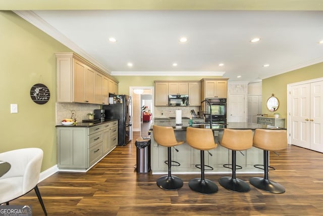 kitchen featuring dark countertops, black appliances, a breakfast bar, and dark wood-style floors