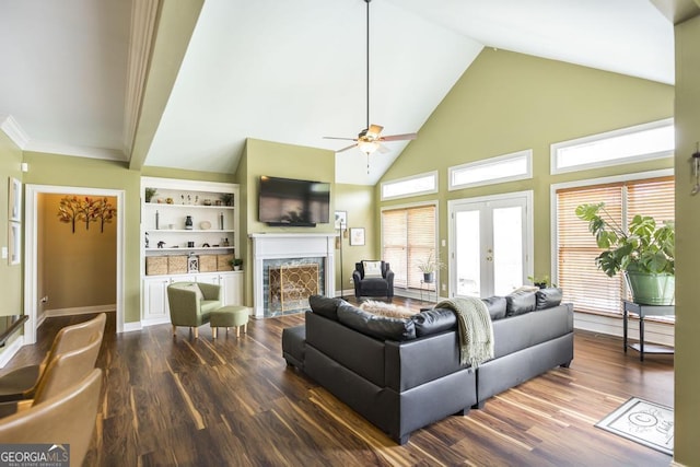 living area with a premium fireplace, a healthy amount of sunlight, french doors, and dark wood finished floors