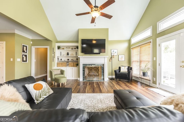 living area featuring high vaulted ceiling, ceiling fan, a high end fireplace, dark wood-style floors, and baseboards