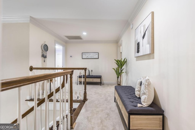 corridor featuring visible vents, baseboards, ornamental molding, an upstairs landing, and carpet floors