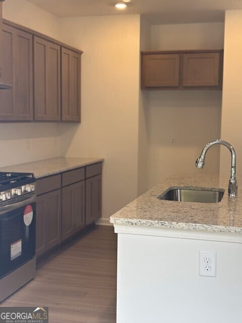 182 Parkwood Dr Unit 32, Dawsonville, GA 30534 - kitchen featuring stainless steel gas range oven, light stone countertops, wood finished floors, a sink, and baseboards