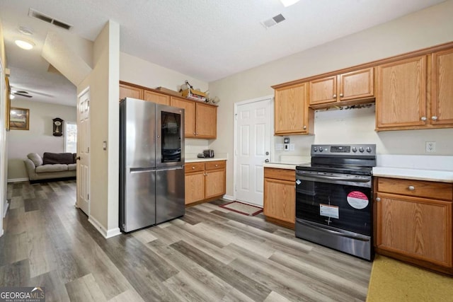 kitchen with visible vents, light countertops, light wood finished floors, and stainless steel appliances