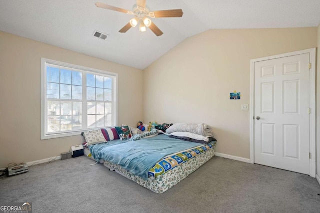 carpeted bedroom featuring visible vents, baseboards, vaulted ceiling, and ceiling fan