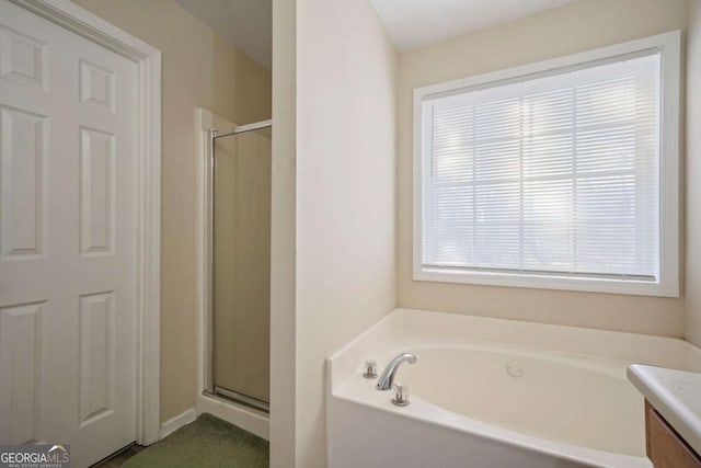 full bath with vanity, a stall shower, and a garden tub