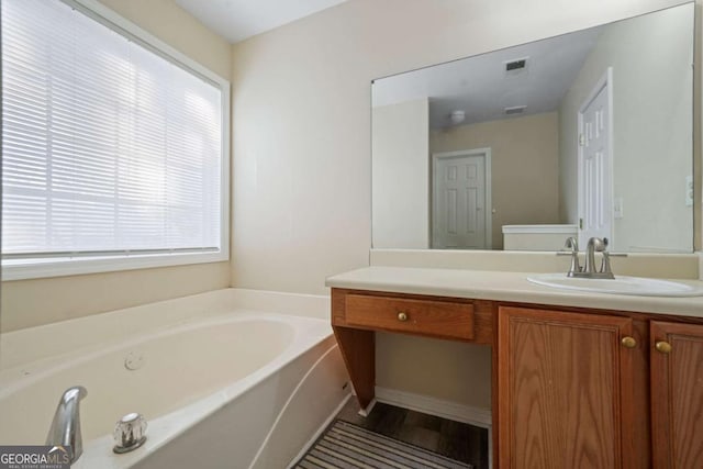 full bath featuring vanity, visible vents, and a garden tub
