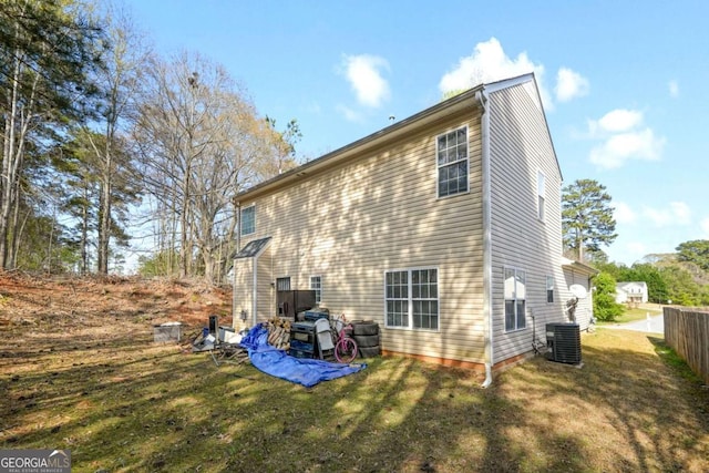 rear view of property featuring a yard and cooling unit