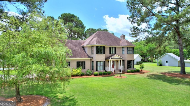 126 N Valhalla Ct, Cordele, GA 31015 - view of front of house featuring a chimney, a front lawn, and a shingled roof