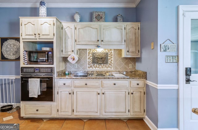 126 N Valhalla Ct, Cordele, GA 31015 - kitchen with oven, stainless steel microwave, decorative backsplash, stovetop, and light tile patterned floors