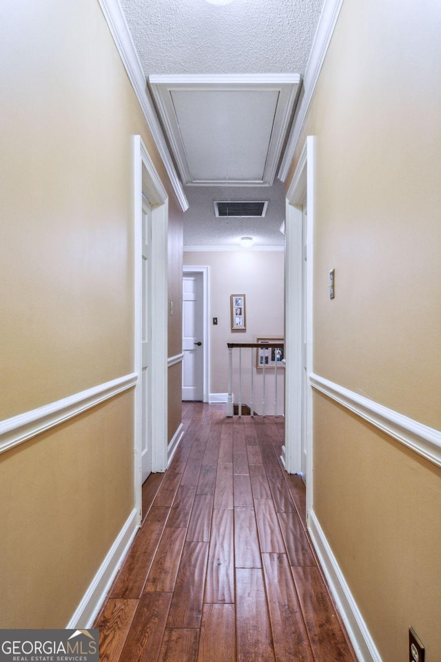 126 N Valhalla Ct, Cordele, GA 31015 - hall with hardwood / wood-style floors, attic access, ornamental molding, a textured ceiling, and baseboards