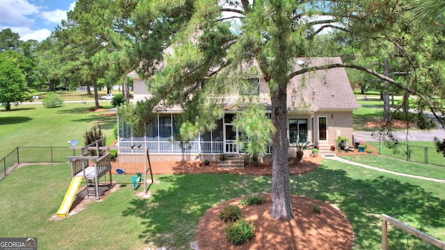 126 N Valhalla Ct, Cordele, GA 31015 - back of house with a sunroom, a playground, brick siding, and roof with shingles