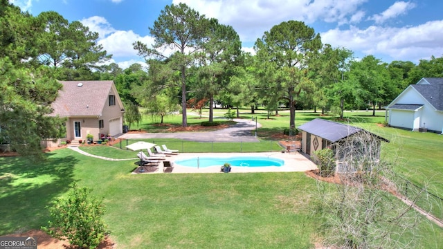 126 N Valhalla Ct, Cordele, GA 31015 - view of green lawn with an outdoor pool, a garage, and view of wooded area