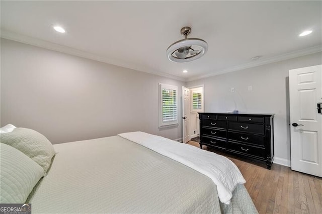 bedroom with recessed lighting, baseboards, crown molding, and wood finished floors