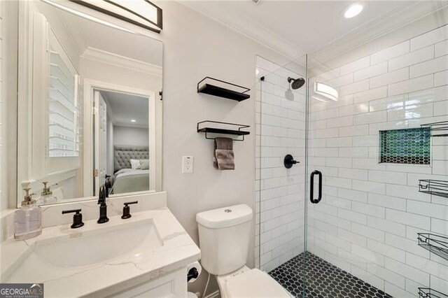 bathroom featuring ensuite bathroom, toilet, crown molding, vanity, and a stall shower