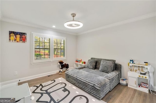 bedroom with crown molding, wood finished floors, and baseboards