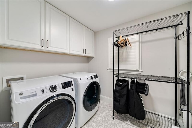 clothes washing area featuring independent washer and dryer, baseboards, and cabinet space