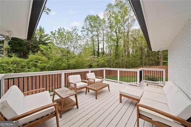 wooden terrace with an outdoor living space