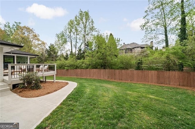 view of yard with a deck and fence