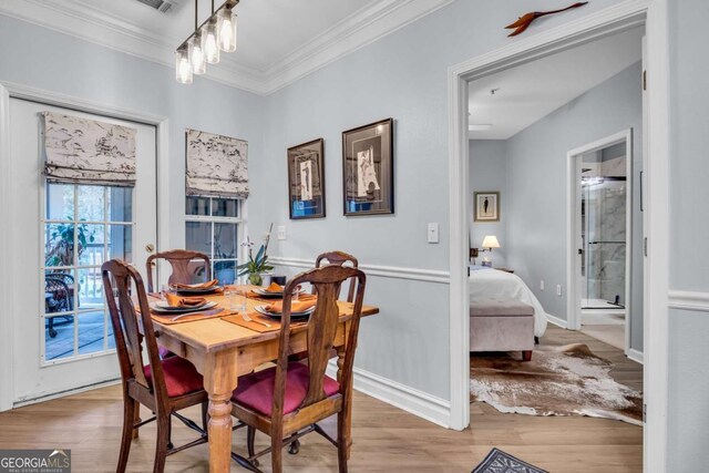 dining area with baseboards, crown molding, and wood finished floors