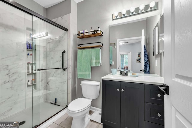 full bathroom with vanity, a marble finish shower, and toilet