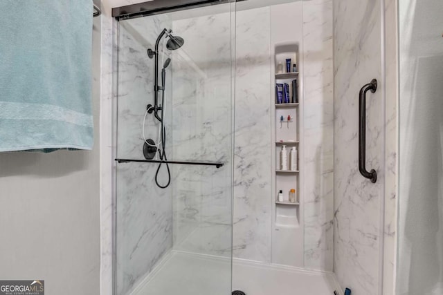 bathroom featuring a marble finish shower