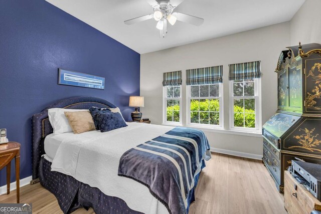 bedroom featuring baseboards, a ceiling fan, and wood finished floors