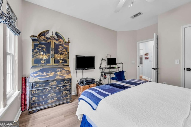 bedroom featuring visible vents, baseboards, a ceiling fan, and wood finished floors