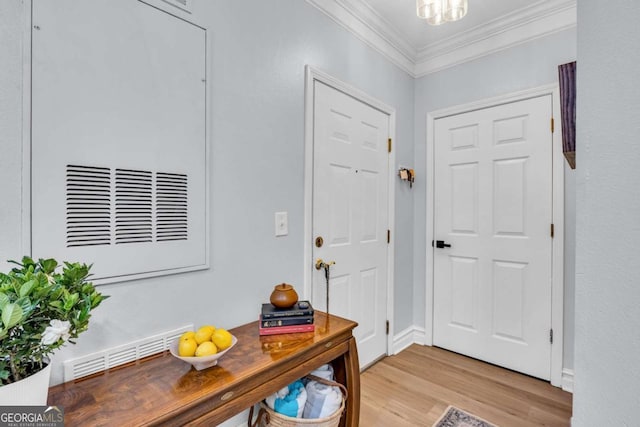 entryway featuring crown molding, baseboards, visible vents, and light wood-style floors