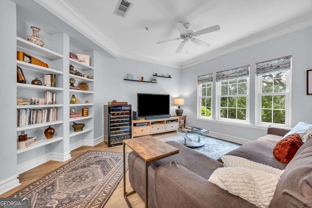 living room featuring visible vents, ceiling fan, wine cooler, crown molding, and wood finished floors