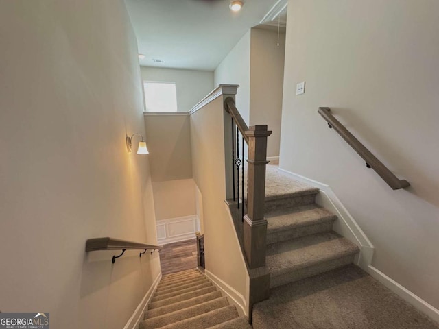 stairway featuring baseboards and carpet floors
