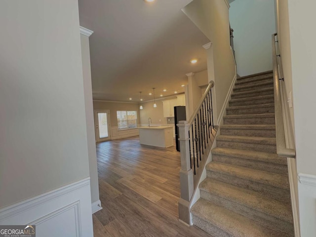 staircase featuring wood finished floors and recessed lighting