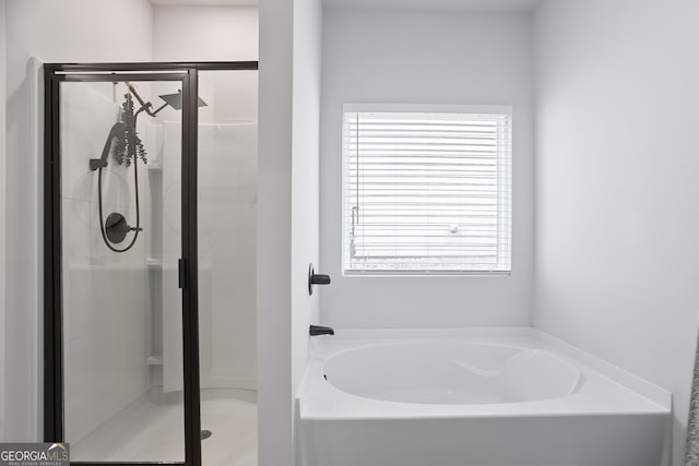 bathroom featuring a stall shower and a garden tub