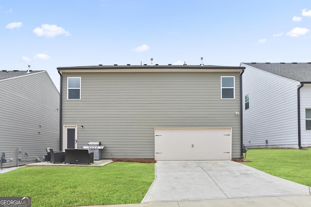 rear view of house with a yard, a garage, and concrete driveway